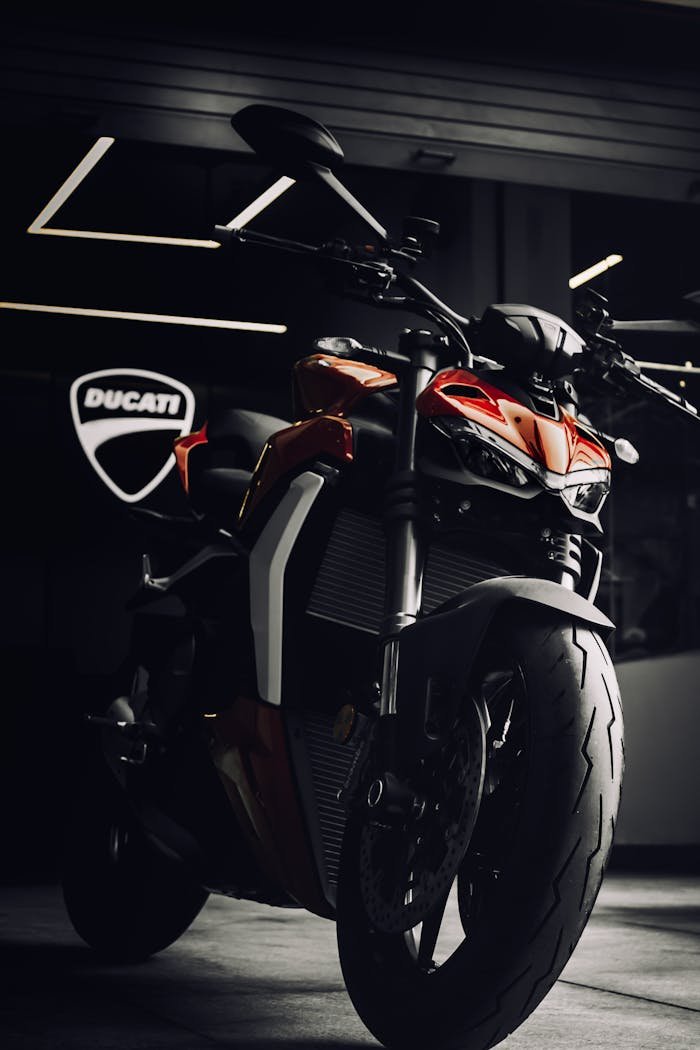 A powerful Ducati motorcycle showcased in a modern indoor showroom setting with dramatic lighting.